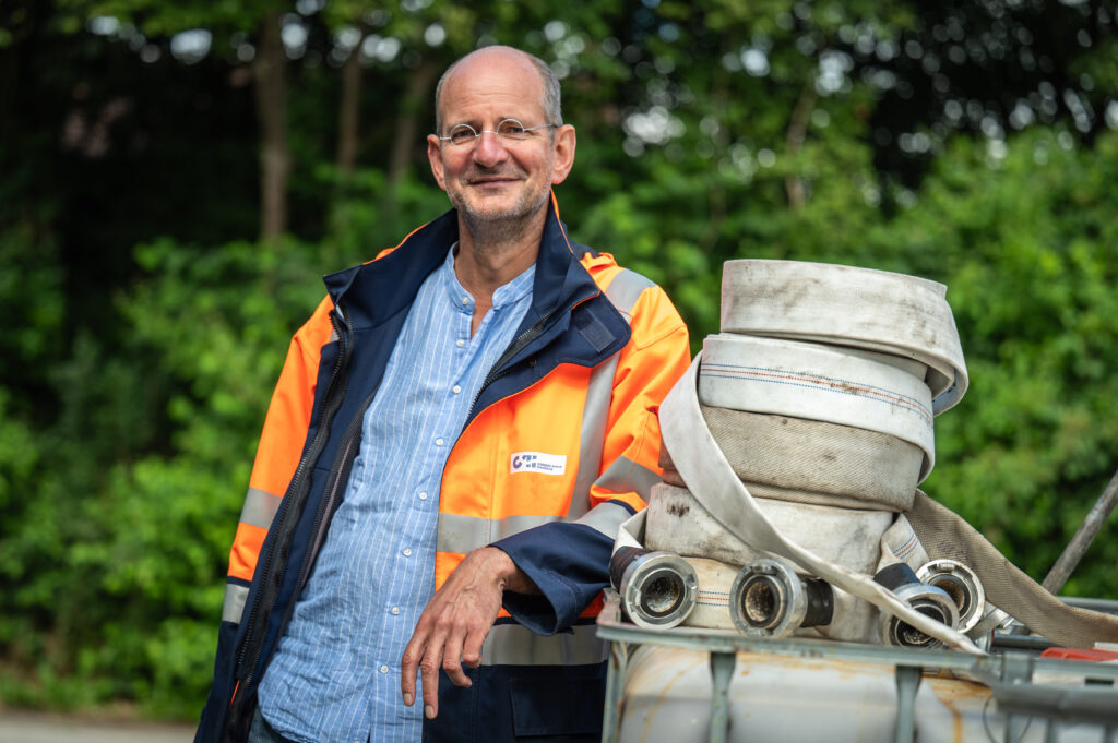 Holger Karkheck Mann lehnt am IBC Tank 1126 Consulaqua